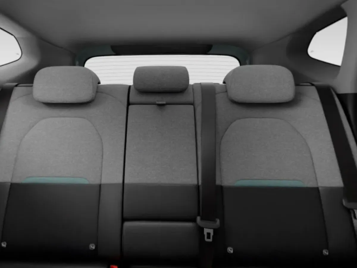 Interior view of the rear bench seats of a Kia Seltos HTE variant, featuring grey fabric upholstery and adjustable headrests.